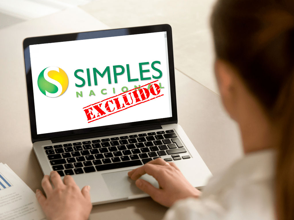 Tela de notebook exibindo a mensagem 'Simples Nacional Excluído', representando risco de desenquadramento e a importância da regularização fiscal.